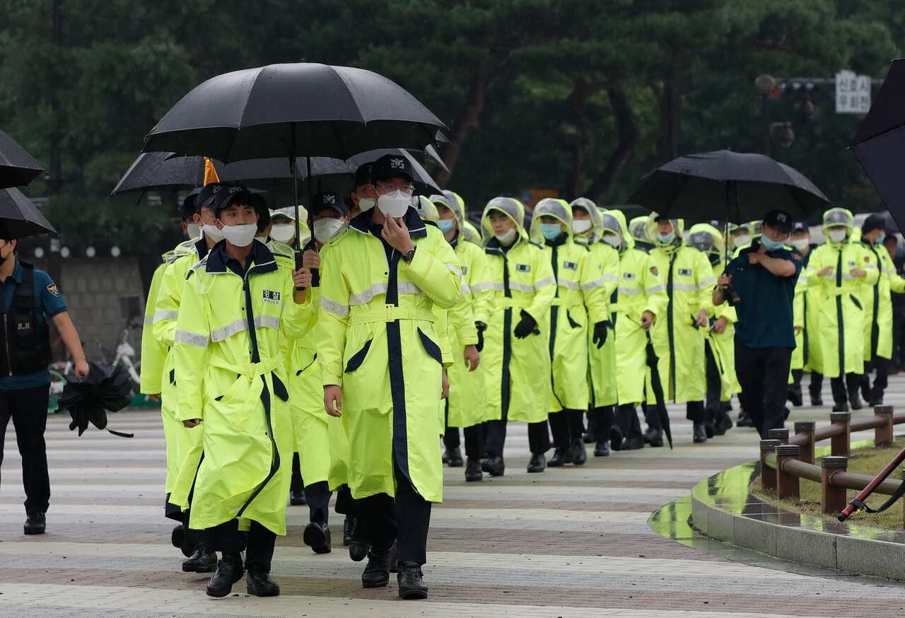 South Korean police officers wearing face masks walk in Seoul, South Korea, Saturday, August 15, 2020
