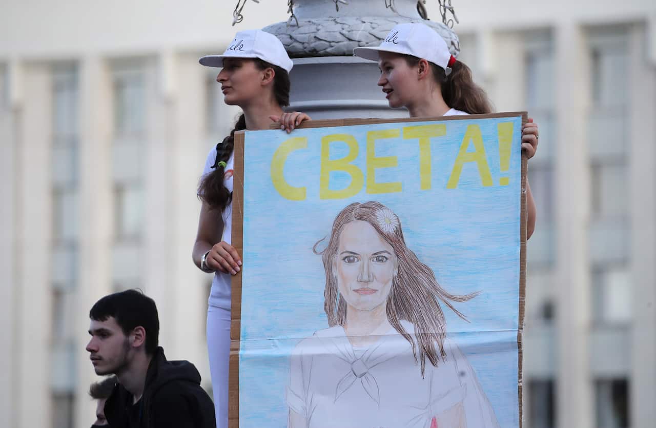 Belarus opposition activists hold a portrait of Svetlana Tikhanovskaya during a protest in front of the parliament building in Minsk, Belarus, on 17 August.