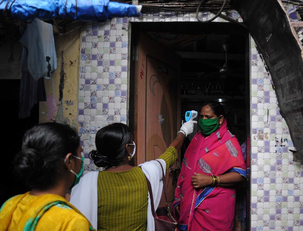 Healthcare worker checks the body temperature of a woman during a free coronavirus screening
