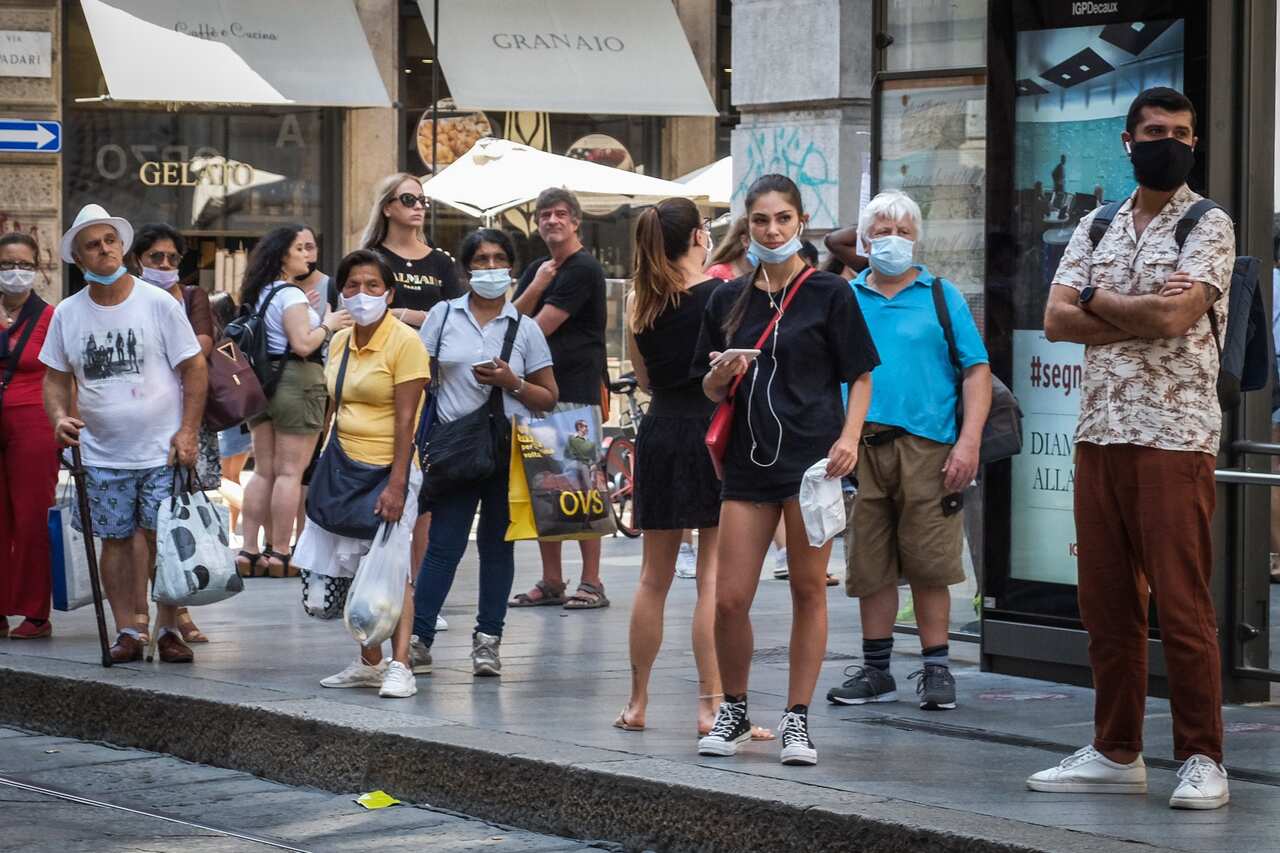 Passers-by wearing protective face masks are seen in downtown Milan, northern Italy.