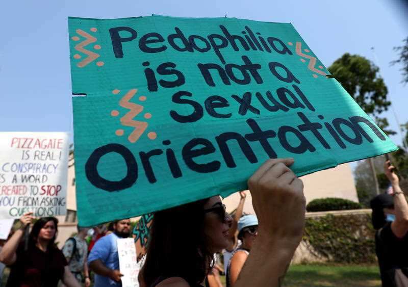 People hold signs as they march in support of the QAnon conspiracy theories in Hollywood.