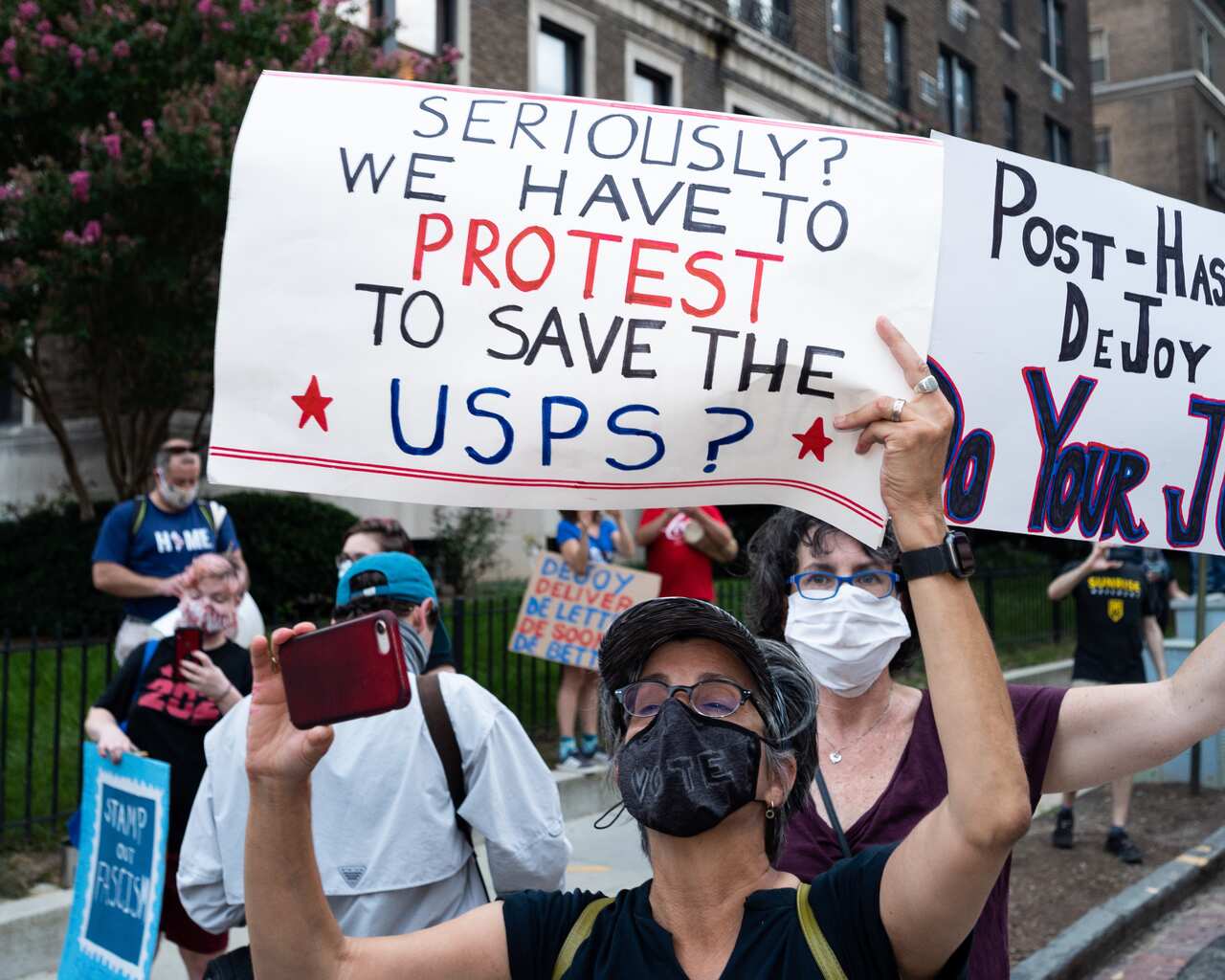 Protesters in Washington DC protest outside the home of USPS Postmaster General Louis DeJoy