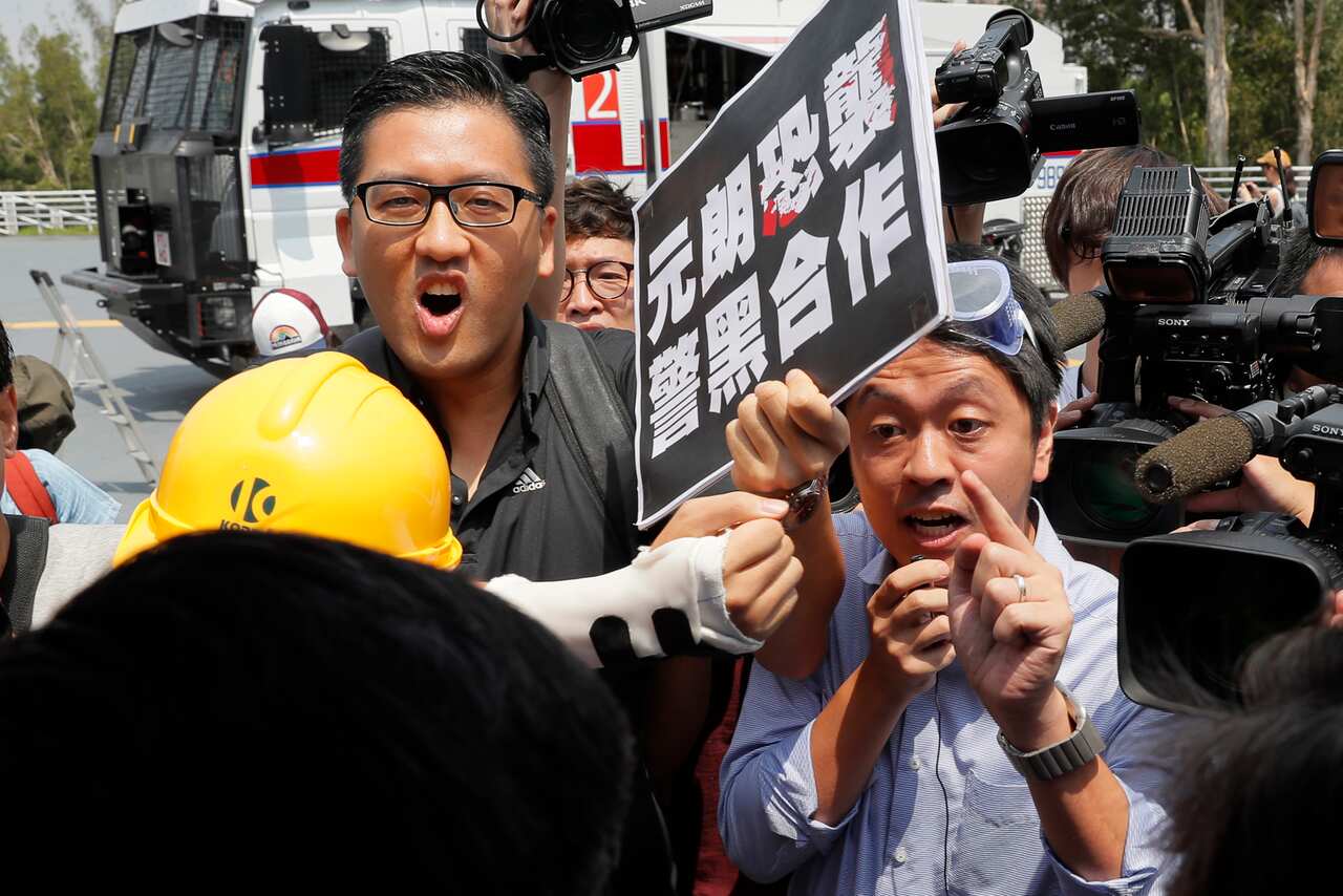 Lam Cheuk-ting, left, and Ted Hu, right, argue with pro-Beijing politician Junius Ho during a demonstration of an anti-riot vehicle.