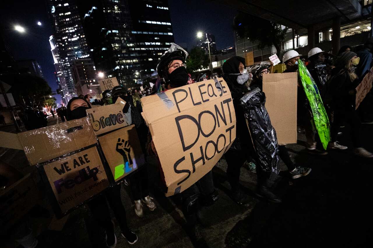A demonstrator holds a makeshift shield as around a hundred protesters gather to protest the shooting in Los Angeles, California.