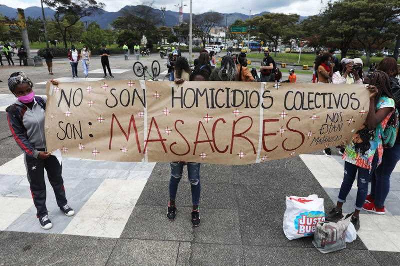  Young people hold a protest banner during a demonstration against the massacres, in Bogota, Colombia.