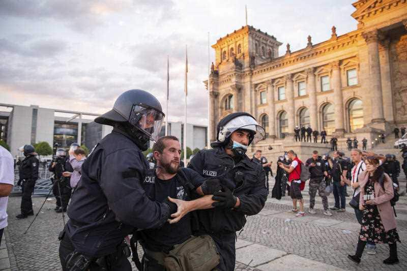 Police officers push away a crowd of demonstrators from the square 'Platz der Republik' in front of the Reichstag building.