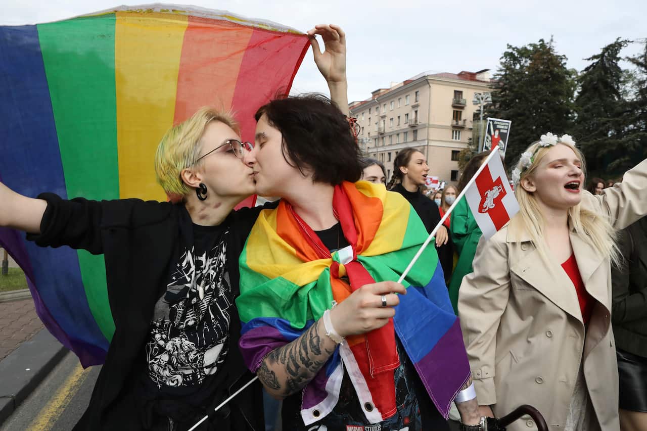 Two LGBT activists kiss while holding rainbow's flags during an opposition rally to protest the official presidential election results in Minsk, Belarus.