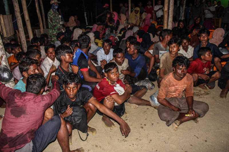 Images from Lhokseumawe showed migrants sitting on the ground in a makeshift building with their possessions.