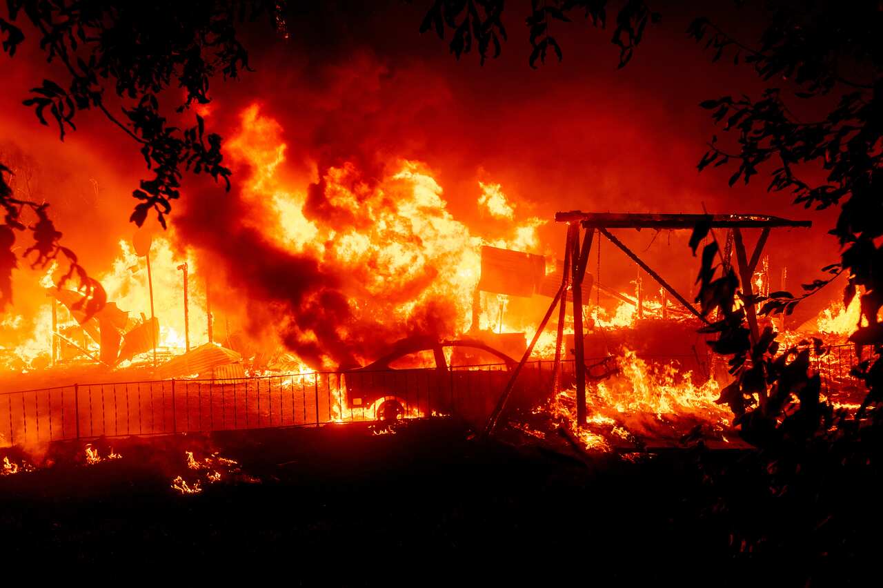 Flames consume a home and car as the Bear Fire burns through the Berry Creek area of Butte County, California on Wednesday, Sept. 9, 2020.