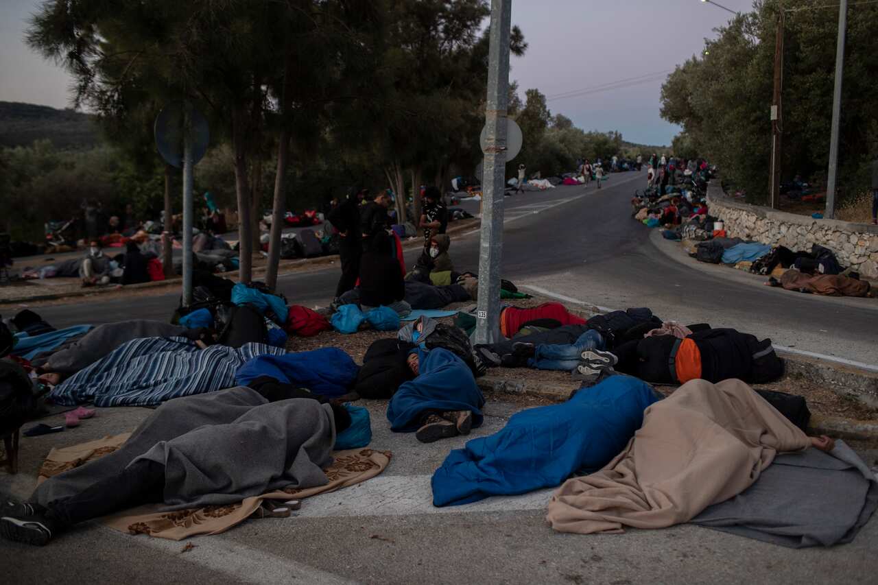 Migrants sleep on the road near the Moria refugee camp on the northeastern island of Lesbos, Greece.