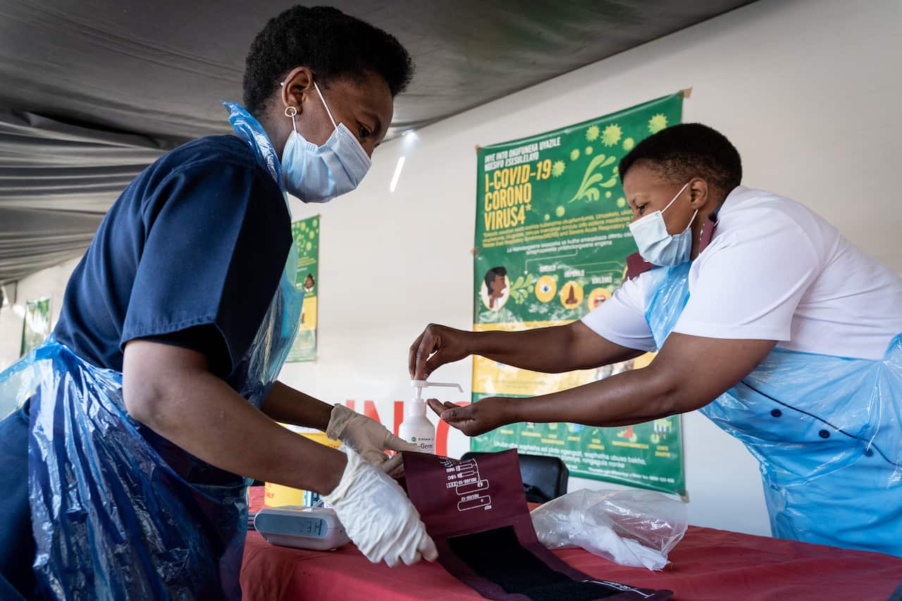 Nurses sanitise themselves and their tools after a patient screening at the Phelophepa Health train in Springs, Johannesburg on 10 August 2020.