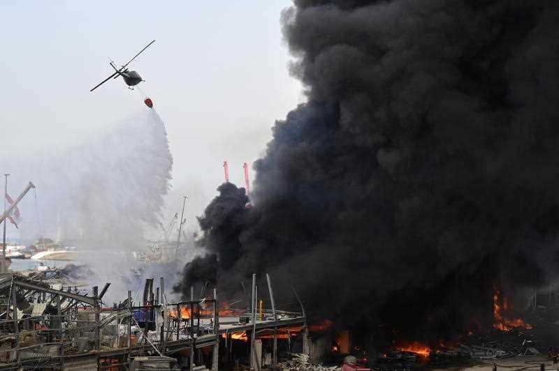 Army helicopter drops water as Lebanese firefighters try to extinguish a fire at a Port of Beirut, Lebanon, 10 September 2020