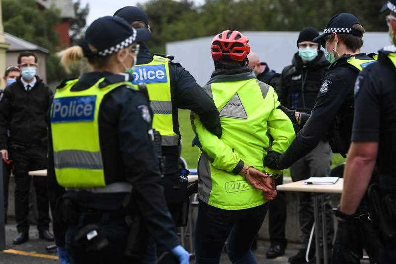 A woman is detained during a planned anti-lockdown protest in Melbourne on 12 September, 2020.