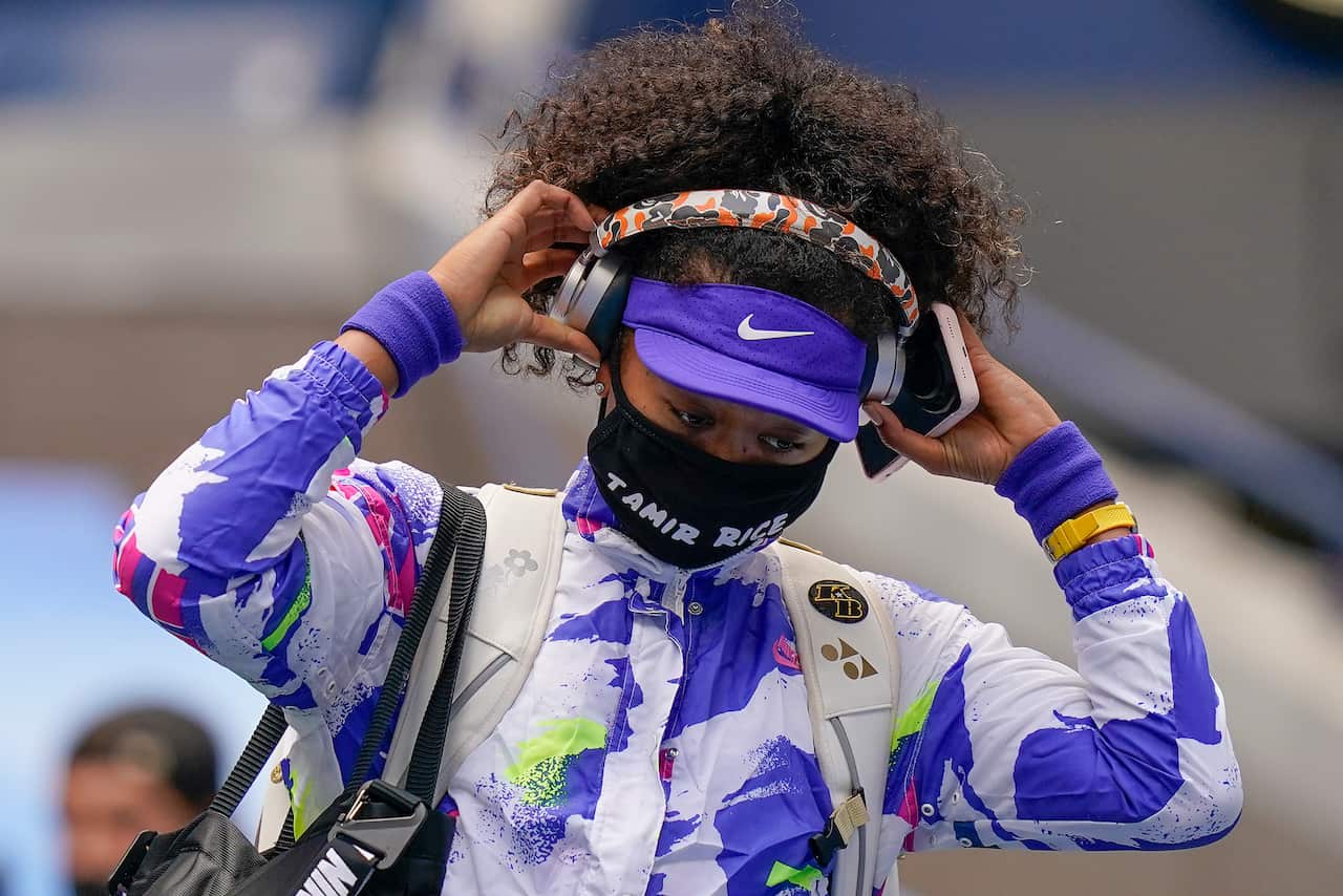 Naomi Osaka, of Japan, pulls off her headphones as she walks on the court before playing against Victoria Azarenka, of Belarus, in the women's singles final of the US Open tennis championships, Saturday, Sept. 12, 2020, in New York. (AP Photo/Seth Wenig)