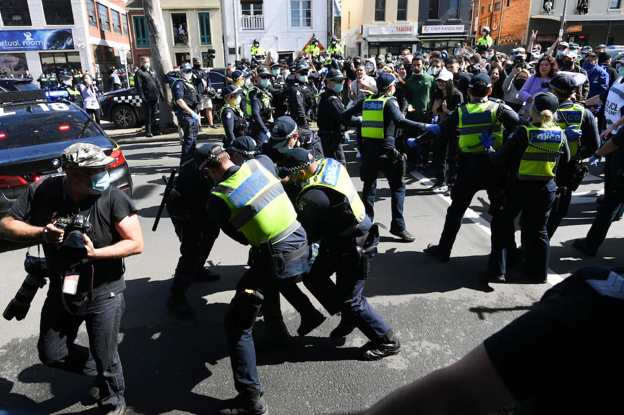 Police scuffle with protesters during an anti-lockdown protest in Melbourne on 13 September. 