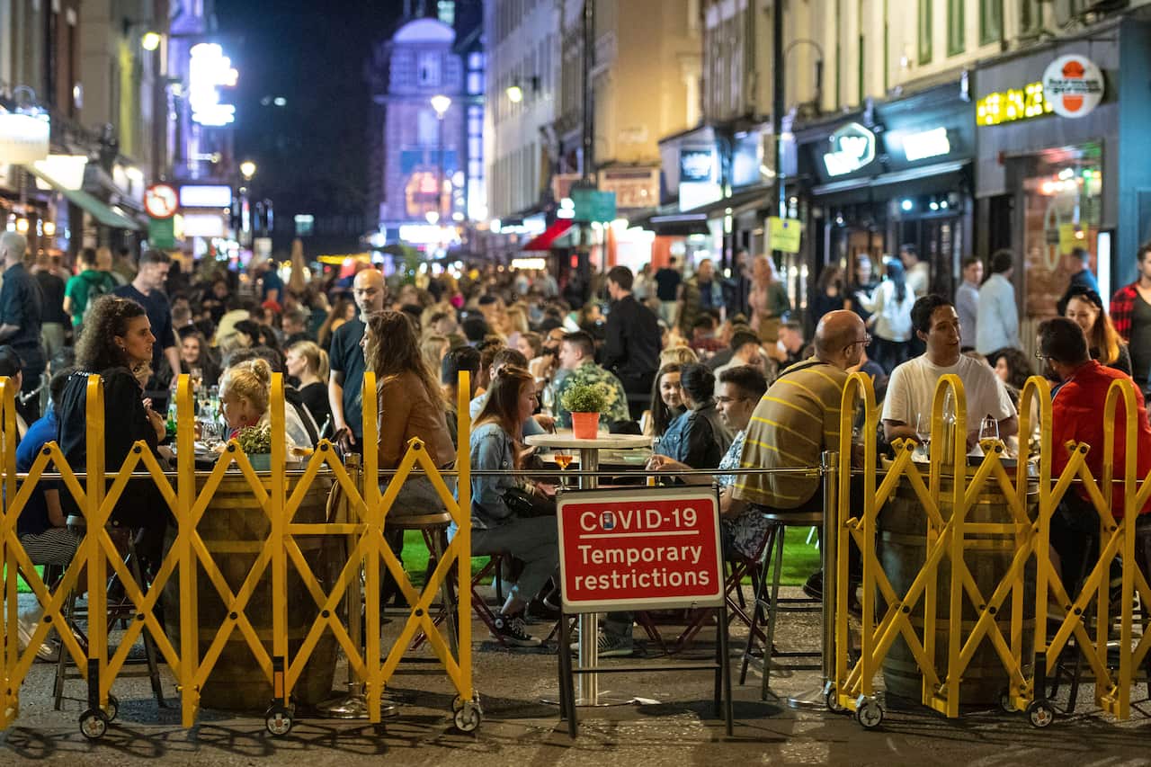 People sit outdoors during a night out in Soho in London's West End on Saturday.