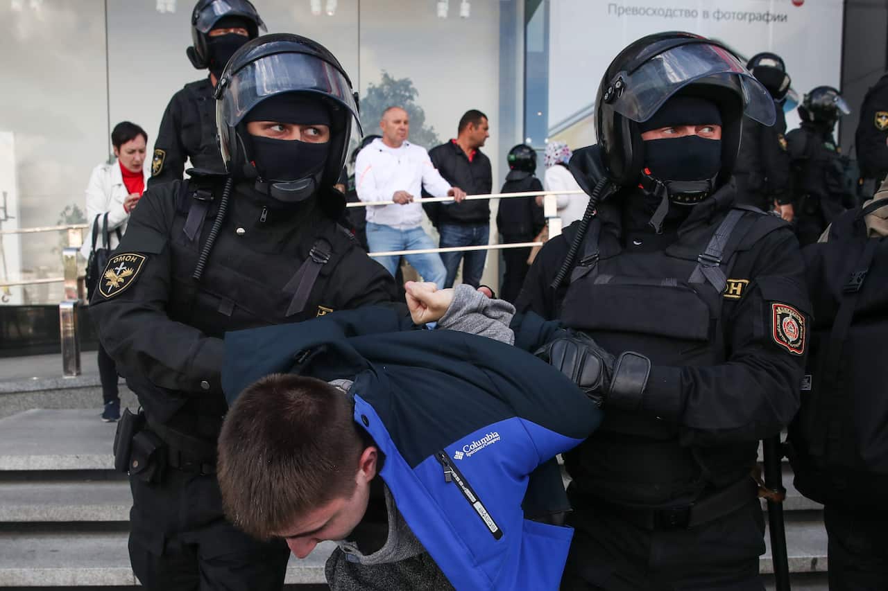 Riot police officers detain a protestor during the rally.