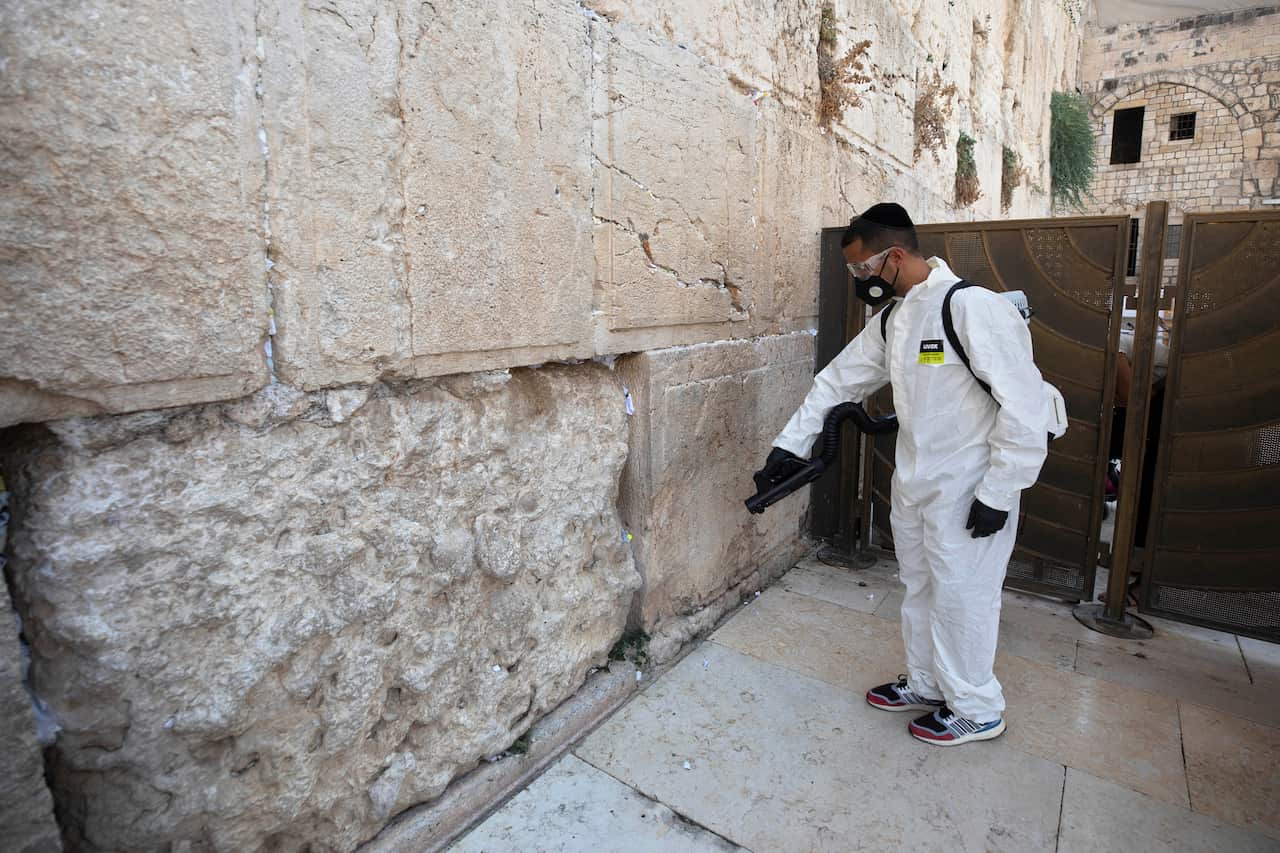 A worker sprays disinfectant as a precaution against the coronavirus at the Western Wall, the holiest site where Jews can pray in Jerusalem, Wednesday, Sept. 16, 2020. (AP Photo/Sebastian Scheiner)