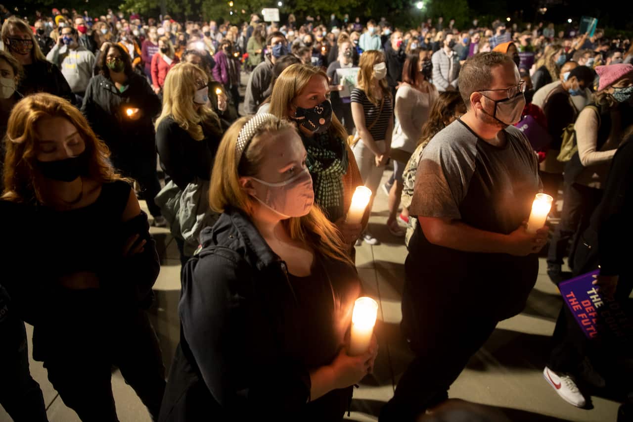 People gather for a candelight vigil to pay their respects to the late US Justice Ruth Bader Ginsburg.