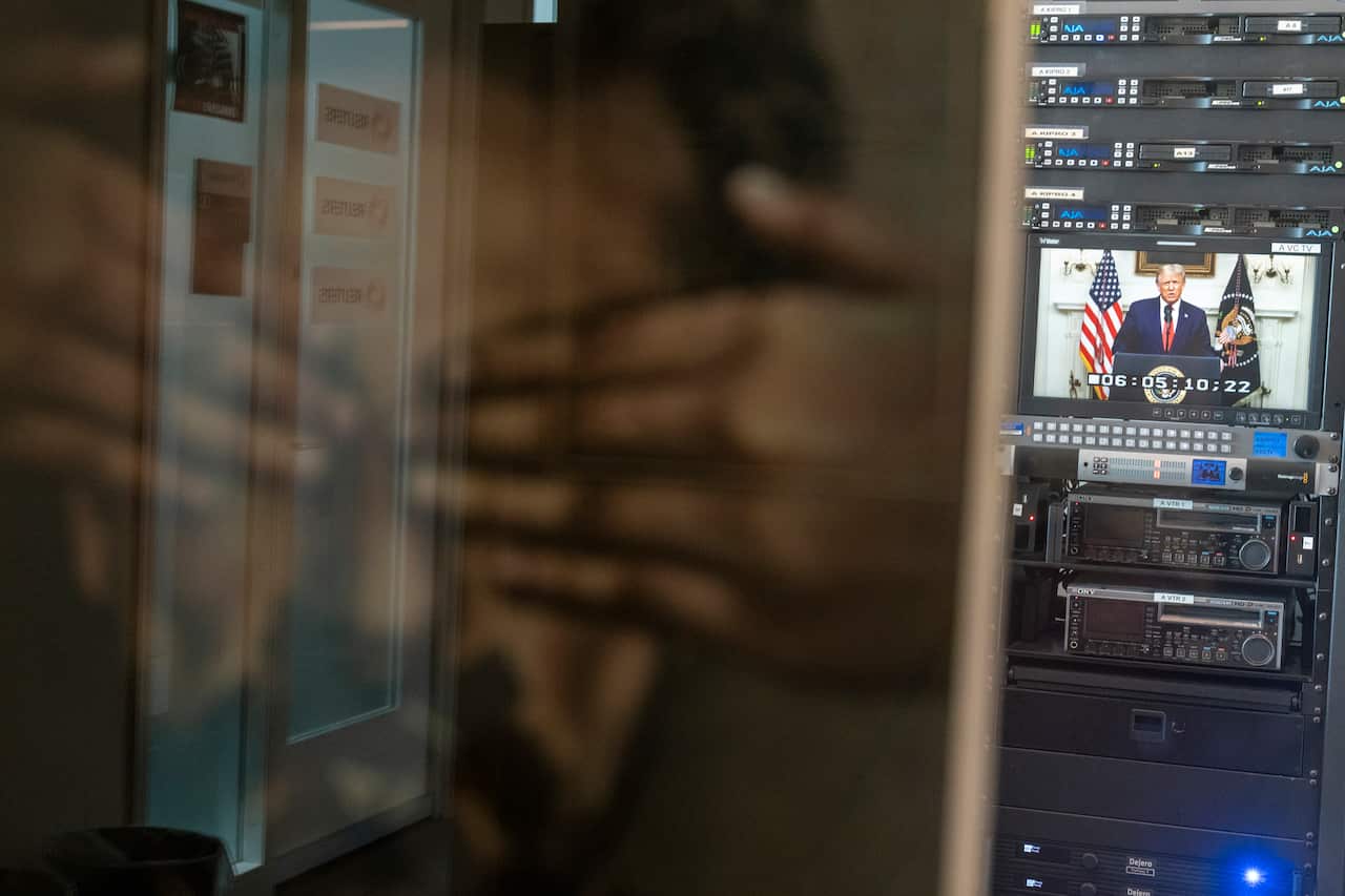 President Donald Trump is framed by a "Journalism is not a crime poster" as he addresses the 75th session of the UN General Assembly.