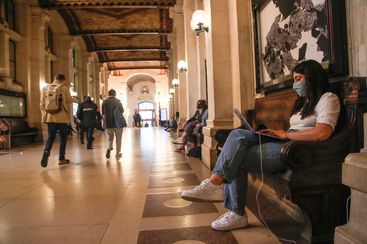 A student of the Pantheon university wearing a face mask to prevent the spread of coronavirus works on her computer at the entrance hall in Paris, France.