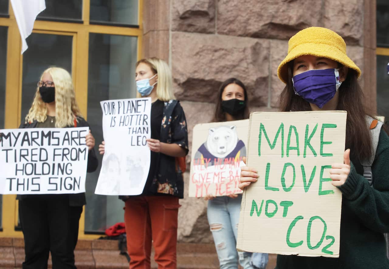 Climate activists hold placards expressing their opinion during a demonstration outside City Hall in Kiev.