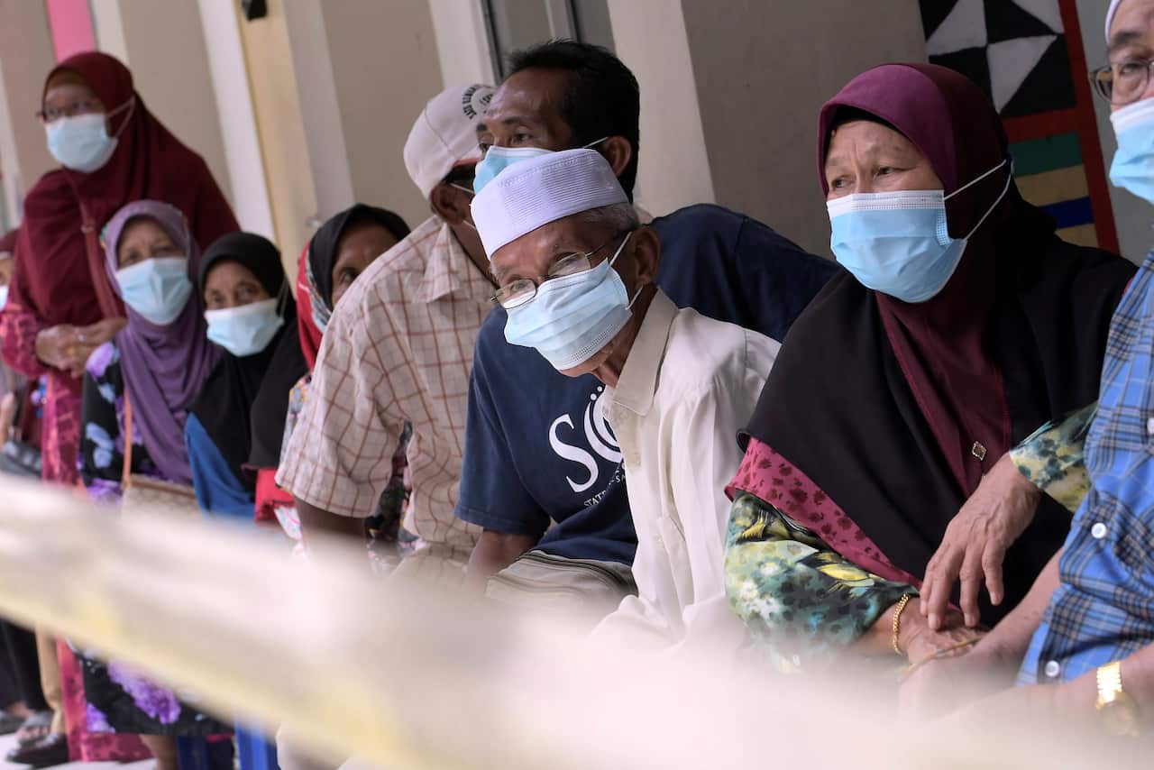 Voters wearing face masks are seen at a polling station during state elections on the outskirts of Kota Kinabalu in Malaysia's Sabah state on 26 September.