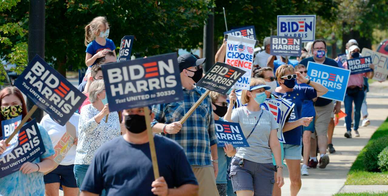 People walk east on West Sixth Street in support of Democratic presidential candidate Joe Biden and running mate Kamala Harris in Erie, Pennsylvania. 