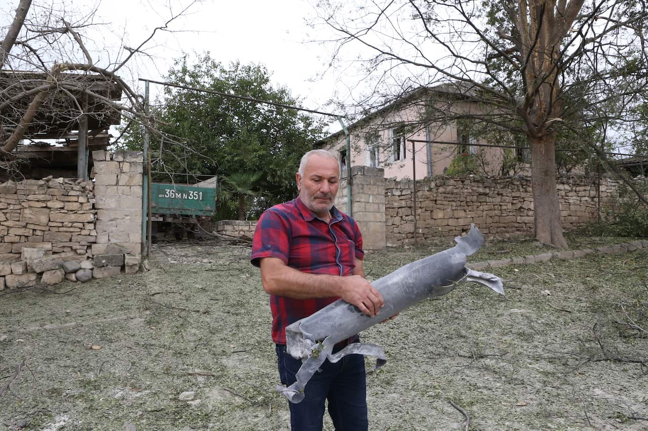A local man carries part of a shell in the city of Martuni in the self-proclaimed Nagorno-Karabakh Republic.