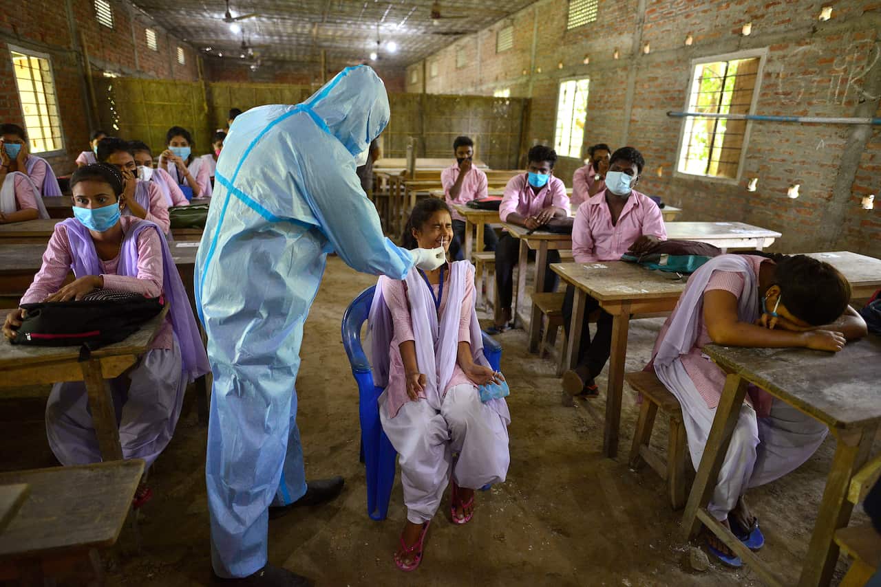 A student reacts as she is tested for COVID-19 at a school in the Morigaon district of Assam, India, on 30 September.