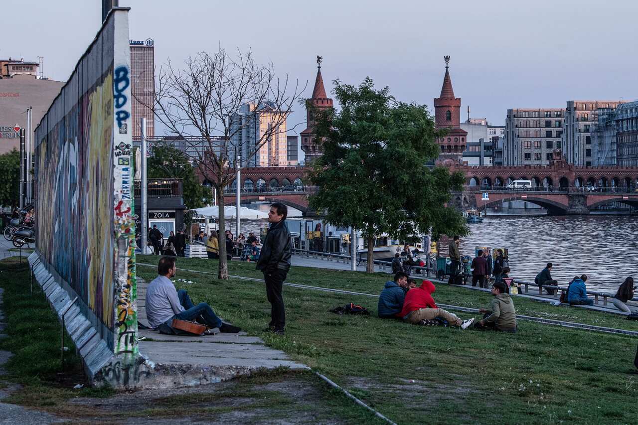 Visitors next to a remaining section of the Berlin Wall at the East Side Gallery in Berlin on 30 September. 