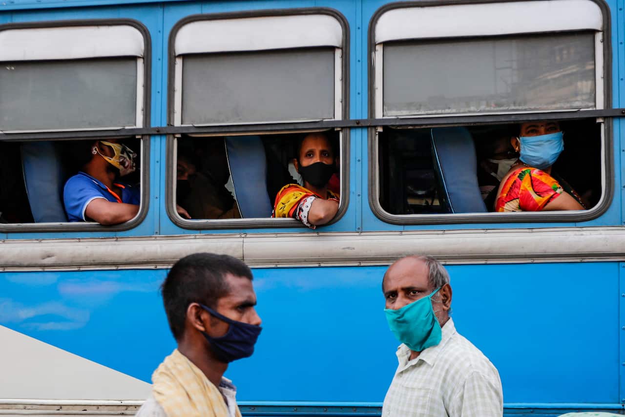 Daily commuters wearing face masks to prevent coronavirus waits inside a bus at a bus terminus in Kolkata, India, on 1 October.