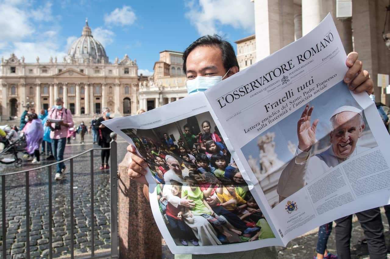 Free copies of the Vatican newspaper L'Osservatore Romano with the front page about Pope Francis' encyclical "All Brothers" are distributed by volunteers.