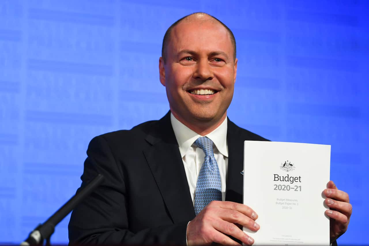 Treasurer Josh Frydenberg holds the Budget papers ahead of delivering an address to the National Press Club.