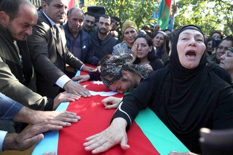 Local people take part in a funeral ceremony for an Azerbaijani serviceman who died in action in one of the border village