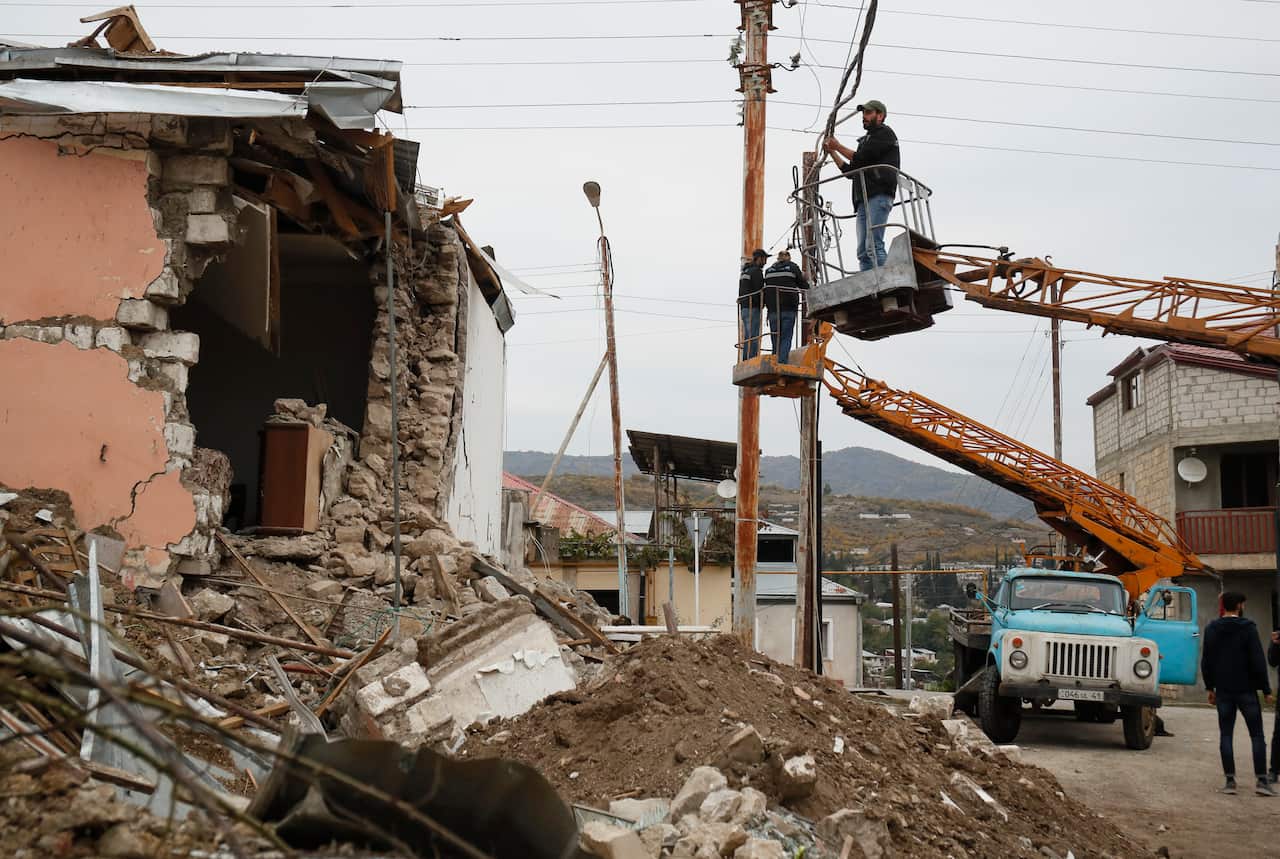 Electricians repair a power line damaged by shelling after the beginning of the ceasefire in Stepanakert, the separatist region of Nagorno-Karabakh.