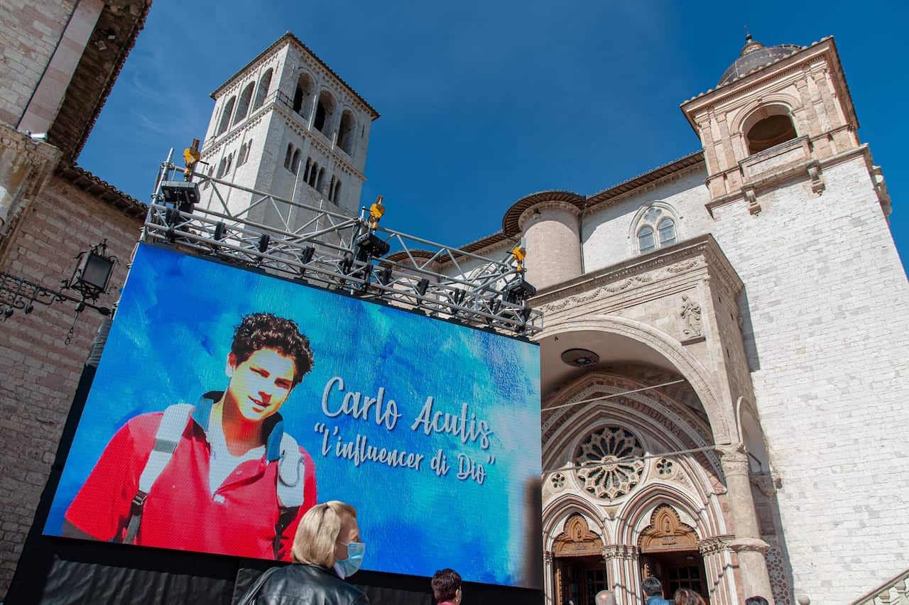 Faithful await the start of mass for the beatification process of Carlo Acutis, at the Basilica of San Francesco.