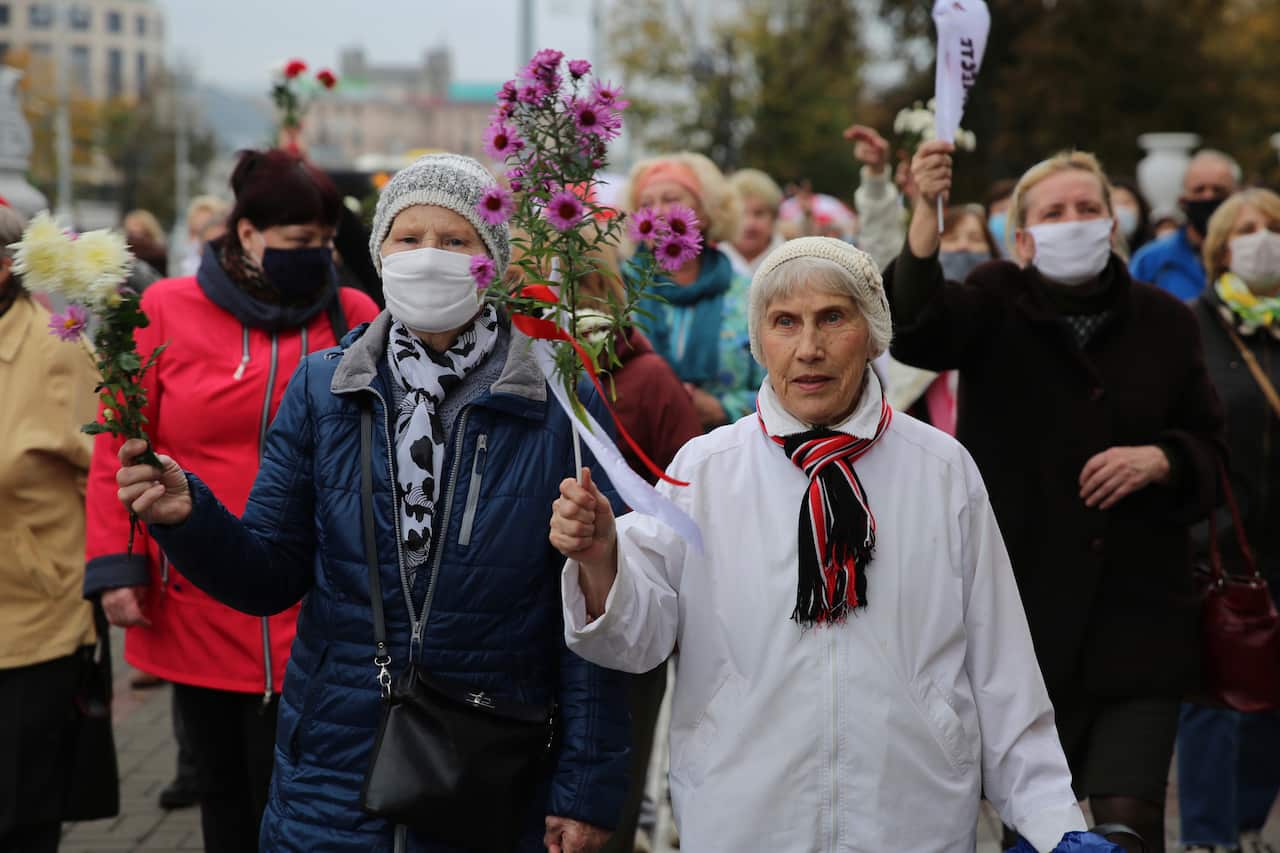 Elderly women hold flowers during an opposition rally to protest the official presidential election results in Minsk, Belarus, on 12 October.