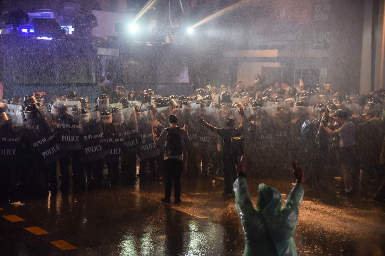 Protesters ask riot police to stop using water cannons.