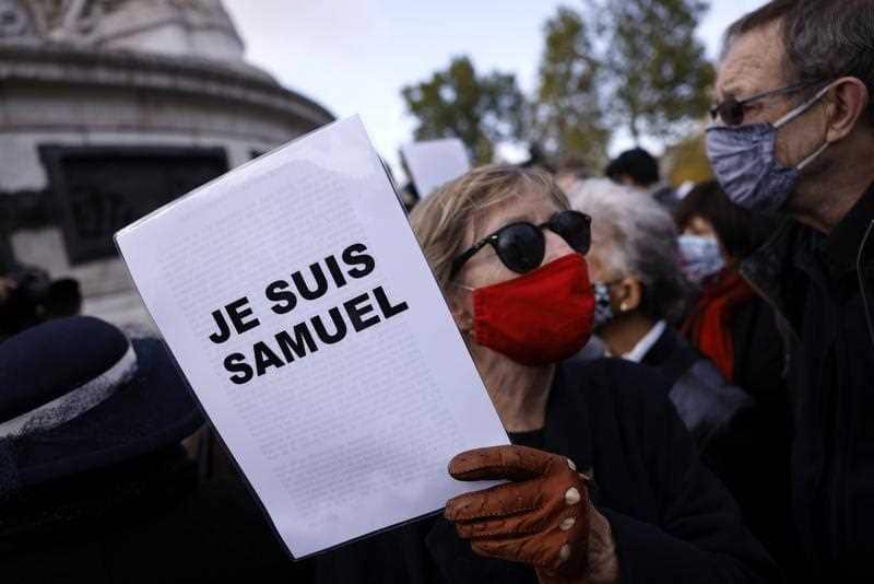 A protestor in Paris carries a sign stating: 'We are Samuel' during a demonstration following the brutal killing of French school teacher Samuel Paty.