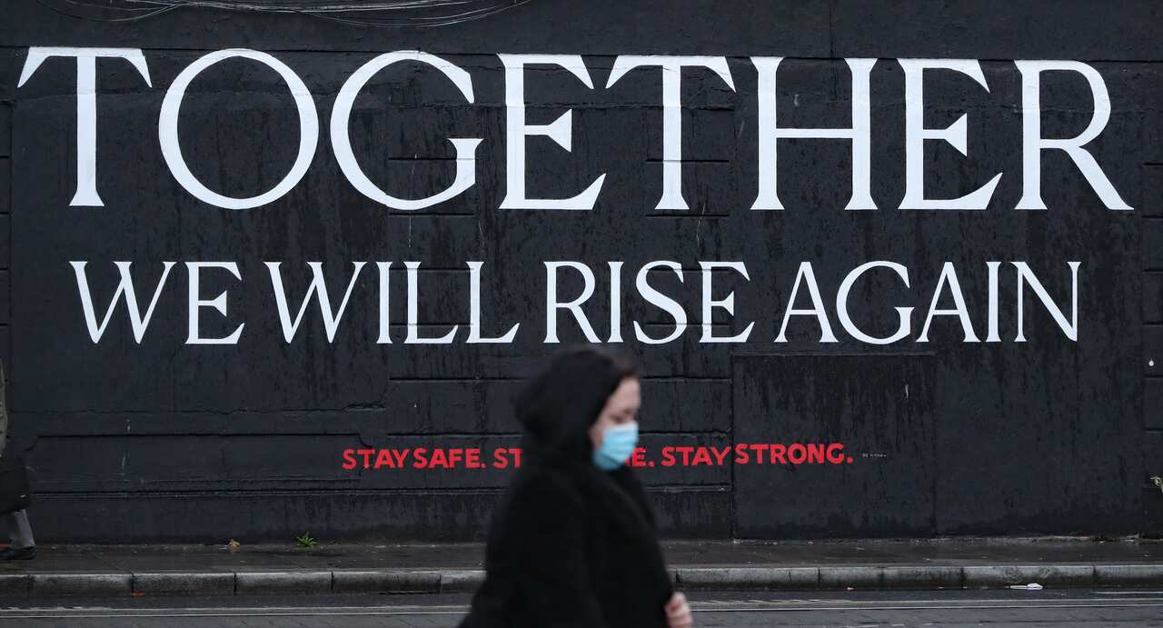 A woman passes a mural in Dublin city centre ahead of the Irish Government announcing further coronavirus restrictions.