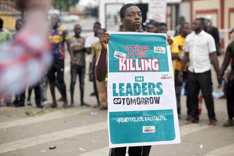 A boy holds a banner in the Ikeja district of Lagos, Nigeria, 19 October 2020