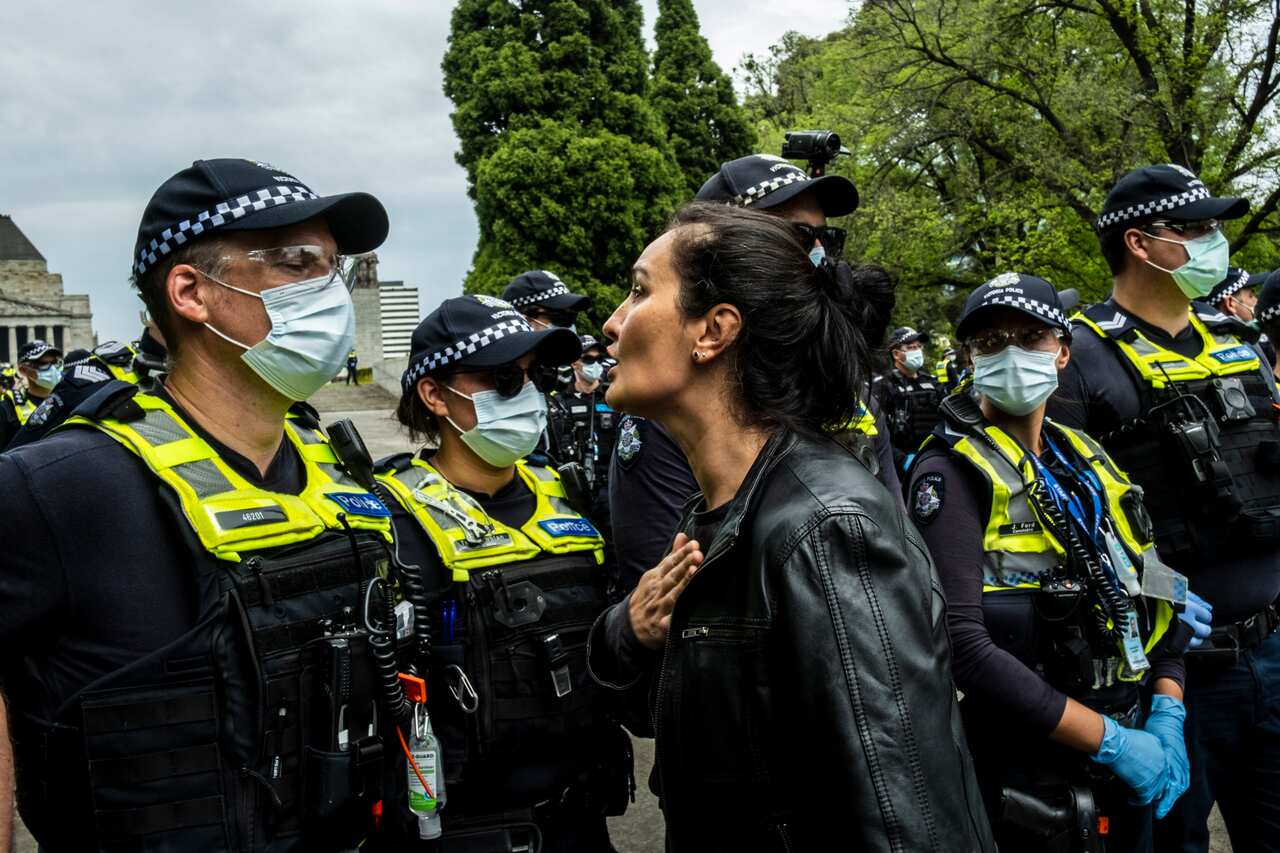A woman talks to police officers at the Shrine of Remembrance during the protest.