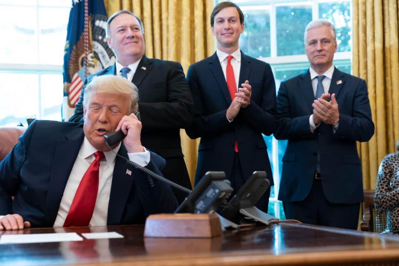US President Donald Trump talks on the phone in the Oval Office of the White House, Friday, Oct. 23, 2020, in Washington. 