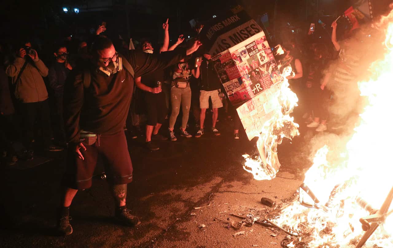 People gather surrounding a fire at Plaza Italia on the day Chileans voted in the referendum. 