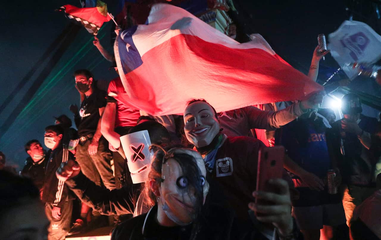 People gather at Plaza Italia on the day Chileans voted in a referendum to decide whether the country should replace its 40-year-old constitution