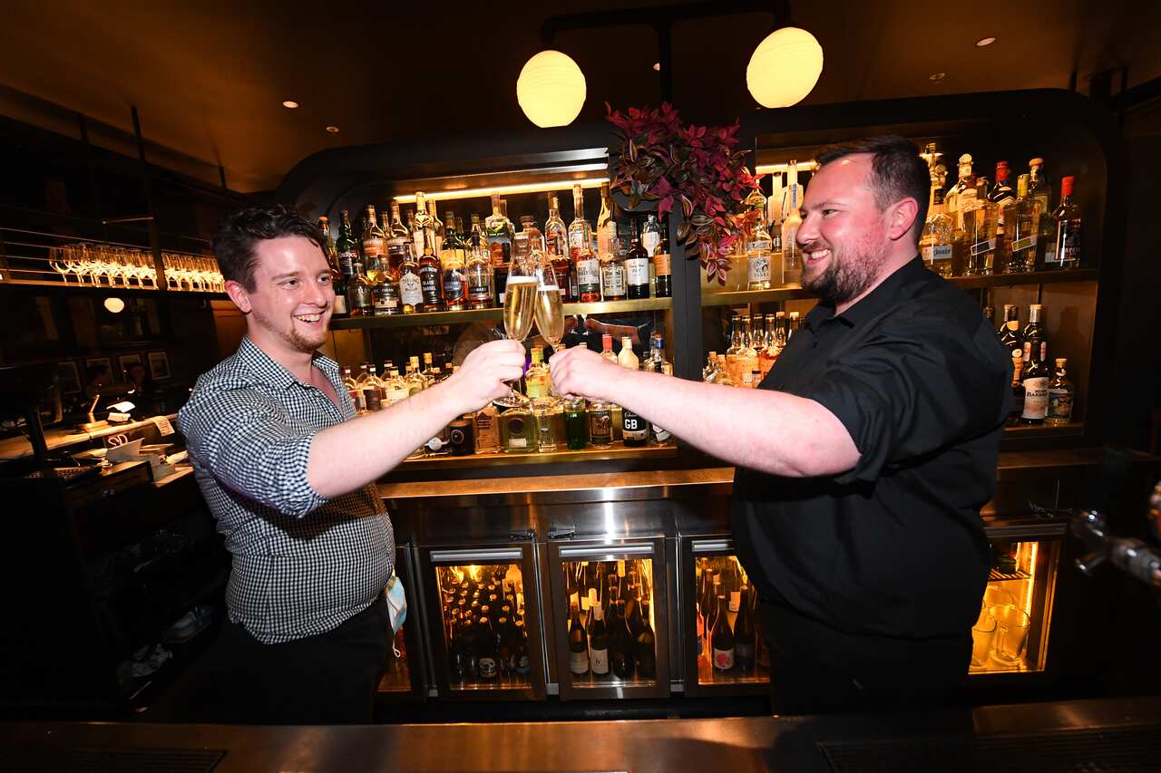 Staff members celebrate eased restrictions behind the bar at Angus & Bon New York steakhouse in Melbourne on 28 October. 
