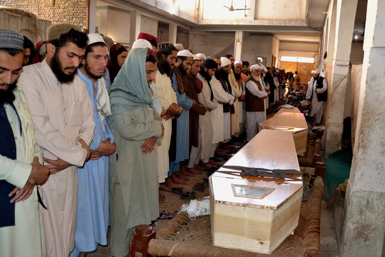 Relatives and people attend the funeral ceremony of victims who were killed in blast at an Islamic seminary in Peshawar, Pakistan.