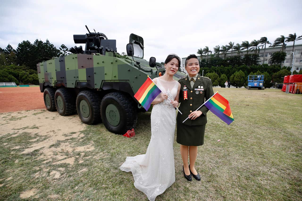 Yi Wang (R) and Yumi Meng (L) pose for a photograph during a military mass wedding in Taoyuan, Taiwan, 30 October 2020. 