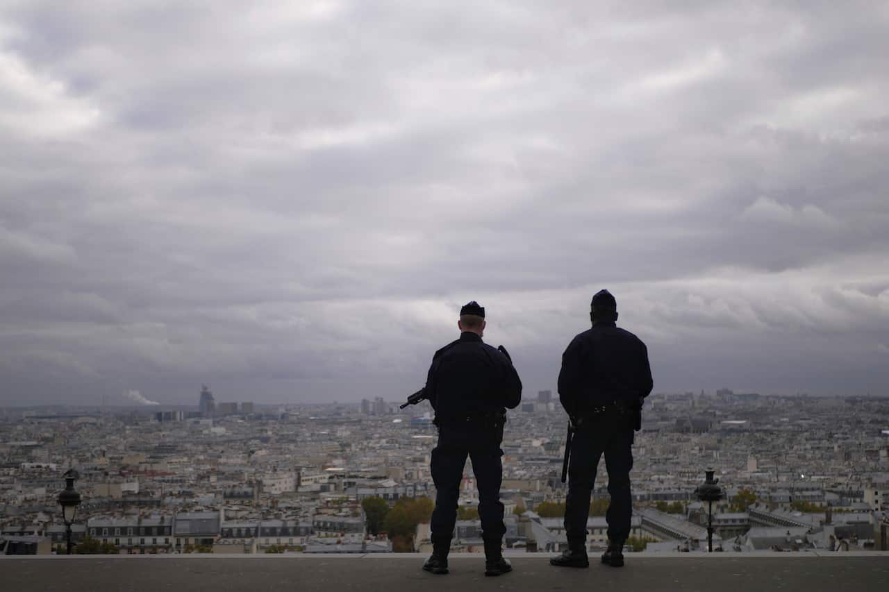 Police officers stand guard next to the Sacre Coeur basilica in Paris, Friday, Oct. 30, 2020. 